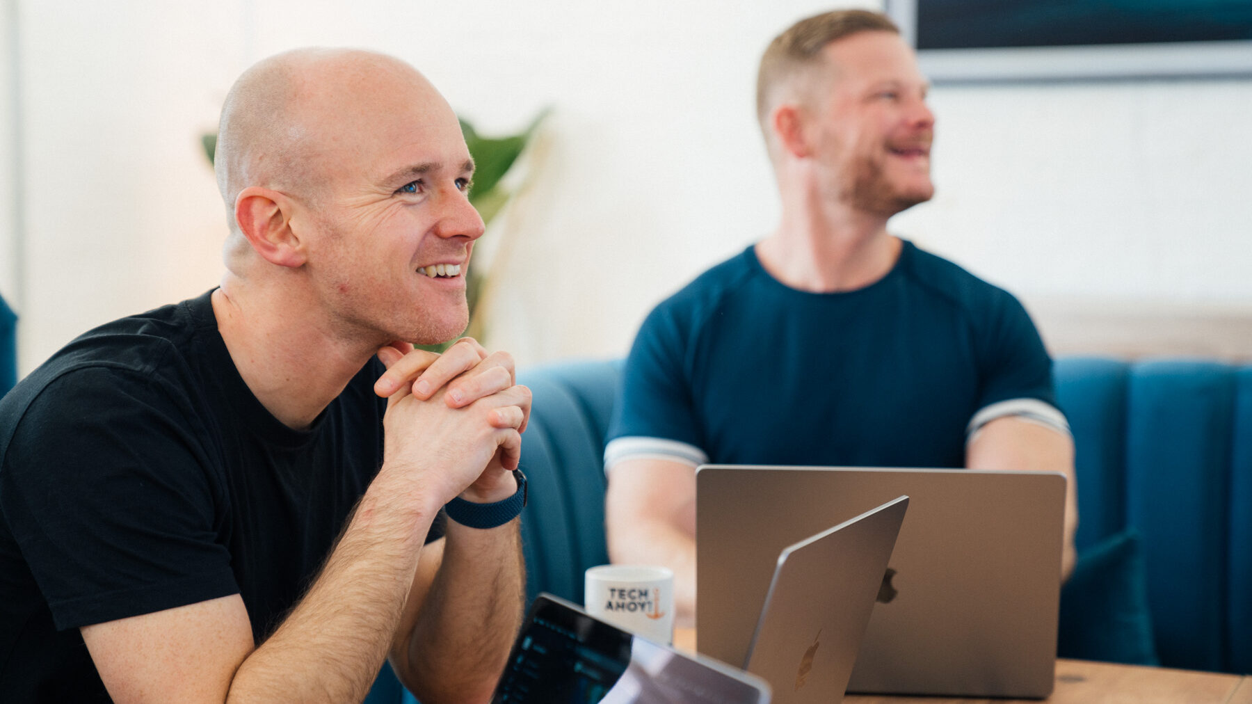 About us 41 FAQs. Crew members laughing by Apple Mac